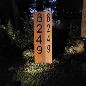 Rustic Double Sided 35-Inch Lighted Modern Steel Address Sign in Rusted Patina with Black Numbers option, illuminated at night with solar spotlight, designed for curb appeal and functionality. Unique rust patterns make each sign one-of-a-kind.